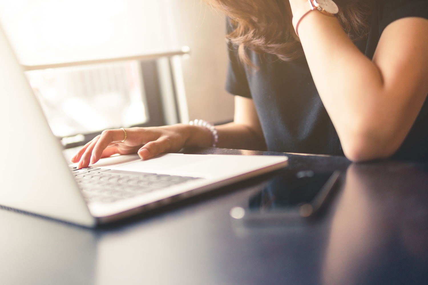 woman working on laptop,business office desk,using laptop computer technology on table for searching and planing successful concept,vintage tone and day light flare.